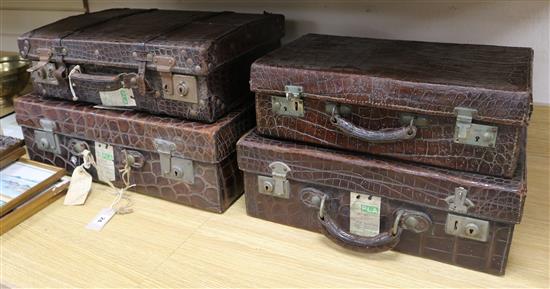 Four 1920s-30s crocodile suitcases Largest 55cm.